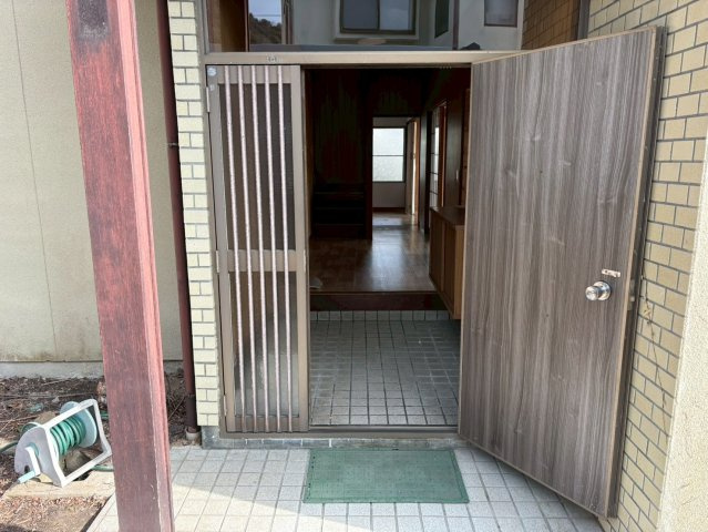 屋根付きの玄関アプローチで、雨の日でも落ち着いて出入りが可能です。木目調の玄関扉が温かみを感じさせ、住まいの第一印象をやさしく演出します。段差も緩やかで使いやすく、来客時にも安心感のある空間です。