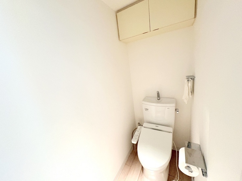 廊下から直接アクセスできる独立タイプのトイレ。上部吊戸棚付きでトイレットペーパー等もすっきり収納。
