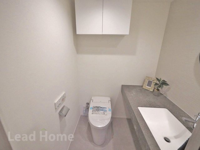 手洗いカウンターと上部吊戸棚を備えたトイレです。ストック品もすっきり隠せて清潔に保てます！