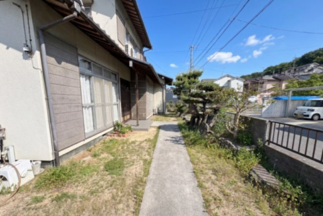 建物まわりにはゆとりある敷地スペースが確保されており、開放感を感じられる住環境です。玄関まで続くアプローチは歩きやすく、庭木が程よいアクセントとなり落ち着いた雰囲気を演出しています。