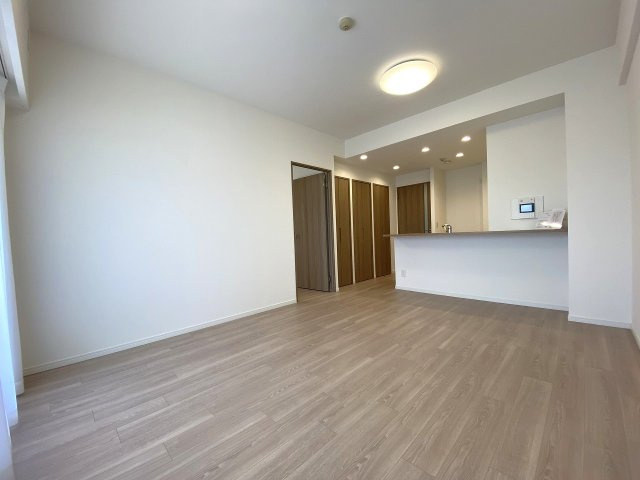 リビング全体を見渡せる開放的な空間設計。新規貼り替え済みの綺麗なフローリングが木目の温かもりを感じさせ、お好みのインテリアを美しく引き立てるシンプルで上質な内装です。