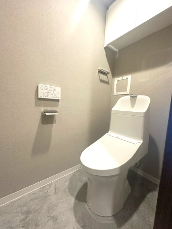 温水洗浄便座付のトイレで、冬の寒い時期でも快適！吊戸棚付きで、予備のペーパー類も問題なく収納できます。