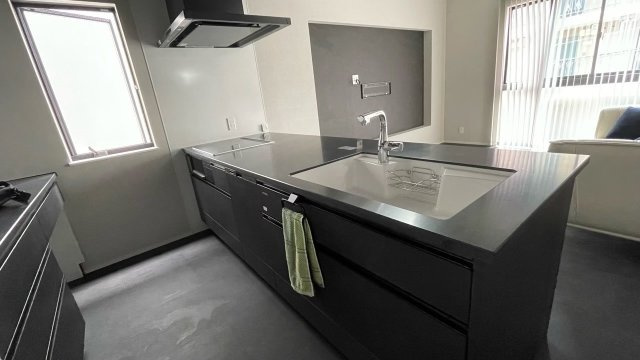 ブラックで統一されたスタイリッシュなアイランドキッチンは、空間全体に高級感を漂わせながら、広いワークトップで作業も快適。食洗機やIHコンロなど設備も充実しており、家事効率の良さが魅力です。