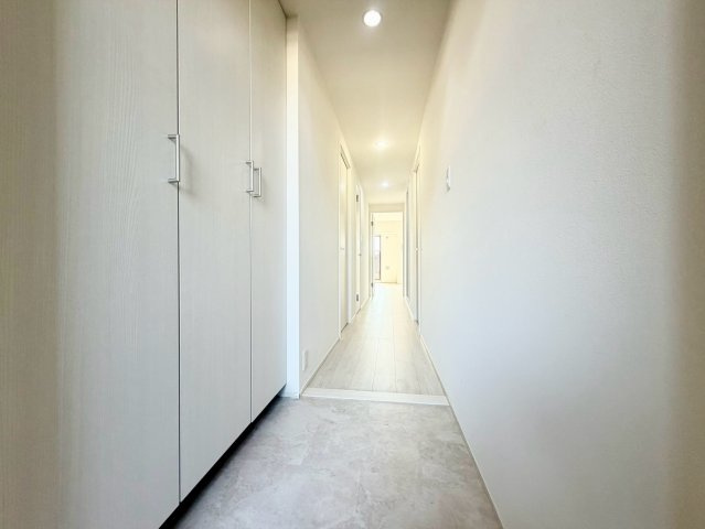 玄関から室内へと続く、すっきりとした廊下。白を基調とした明るく清潔感のある内装です。