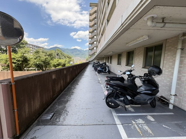 共用廊下は幅にゆとりがあり、開放感のある空間が広がります。屋根付きで整備されているため、大切なバイクを雨や直射日光から守りながら保管可能となっており、毎日の暮らしを快適にサポートしてくれます。