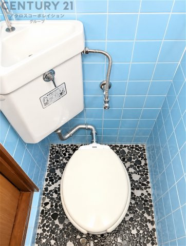 ブルーのタイルが爽やかな印象のトイレ空間。コンパクトながら使いやすく、手洗いスペースも備えています。毎日気持ちよく使える、清潔感のある水回りです。
