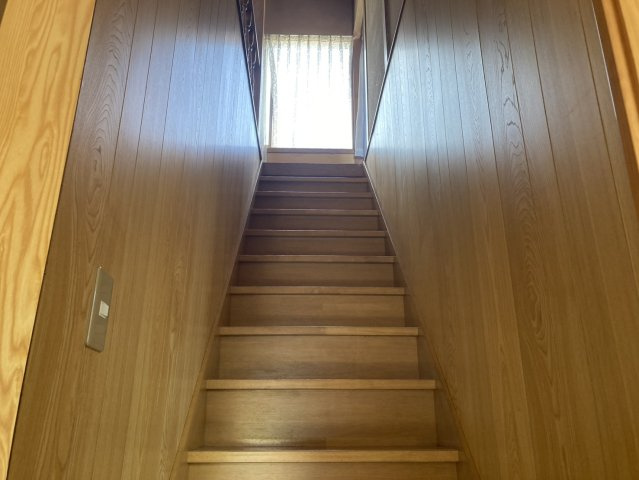 木目を基調とした温かみのある階段です。正面上部には窓が設けられており、自然光を取り込めるのもポイント。1階から2階へとつながる空間にも木の風合いが感じられ、住まい全体の落ち着いた雰囲気と調和しています