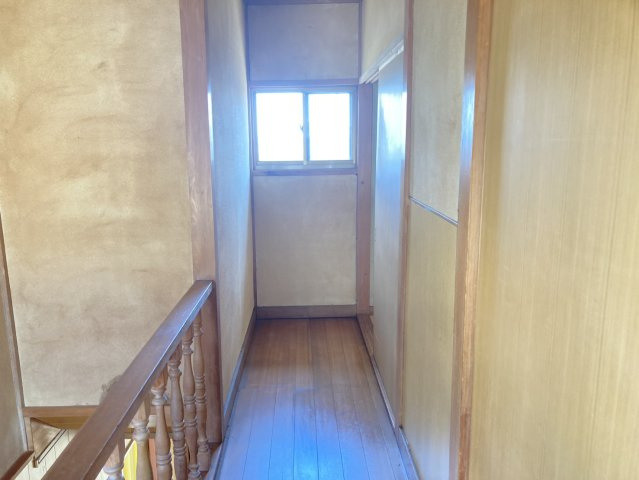 各居室へとつながる2階廊下。突き当たりには窓が設けられており、自然光を取り込める明るい空間です。木目の床や手すりが住まい全体の落ち着いた雰囲気と調和し、どこか懐かしさと温もりを感じさせます。　