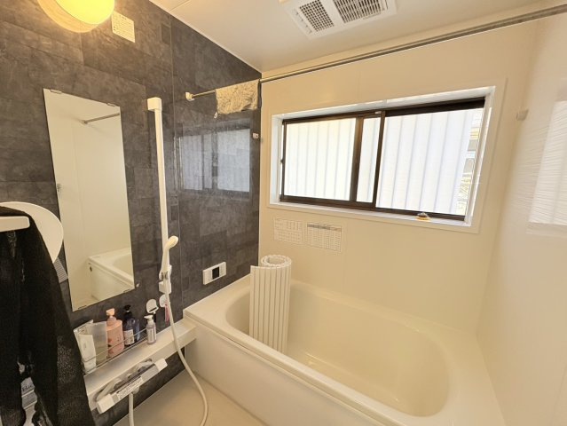 落ち着いた色合いのアクセントパネルが印象的な浴室。ゆったりとした浴槽で、一日の疲れをしっかりと癒すことができます。窓付きのため換気もしやすく、湿気がこもりにくいのも嬉しいポイントです。