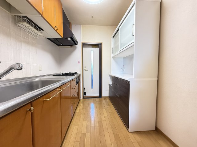 作業スペースにゆとりのあるキッチンです。上下収納に加え、カップボードも備えられており、食器などをすっきり収納できます。勝手口が設けられているため換気しやすく、ゴミ出しやちょっとした出入りにも便利です。