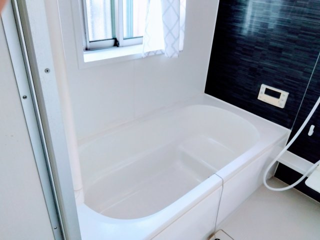 窓があるので明るい室内です。黒いタイルがアクセントになっていてオシャレです。備え付けの台があるのでシャンプーを置いたり出来て便利です。