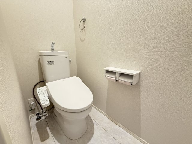 落ち着いた雰囲気のトイレは、清潔感あふれるシンプルなデザインが魅力です。温水洗浄便座付きで快適に利用でき、ペーパーホルダーも2連仕様で使い勝手良好。ゆとりある空間が毎日の生活をより快適にしてくれます。