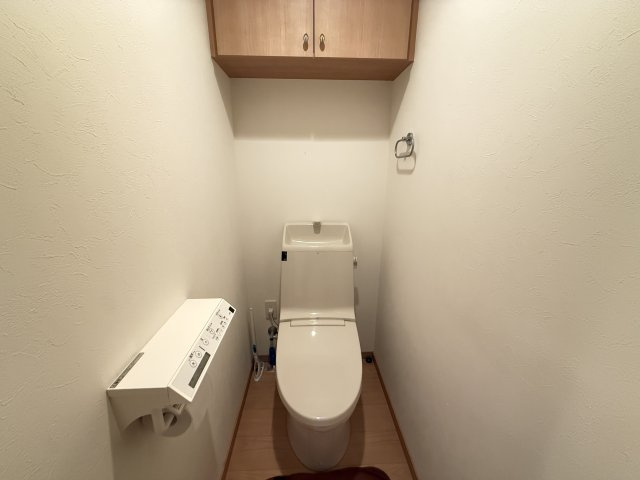 清潔感のある温水洗浄機能付きトイレ。手洗いカウンター一体型で使いやすく上部には収納棚も備えています。生活感をすっきり隠せる設計で日用品のストックも整理可能。落ち着いた空間で快適にお使いいただけます。
