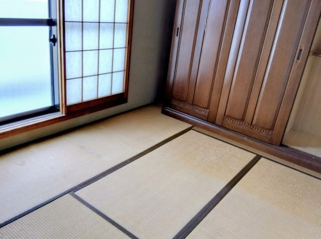 障子から優しい光が差し込む和室です。大型の木製収納も備わり、寝室や客間として多用途に使える寛ぎの空間です。