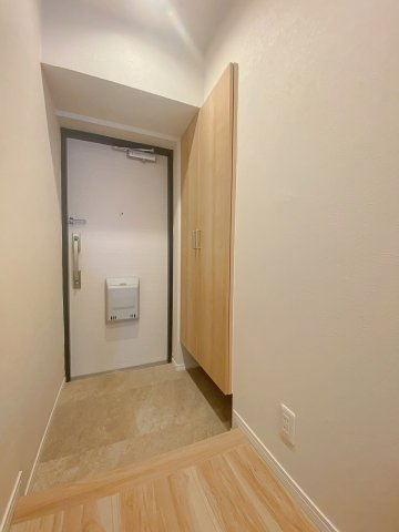 住まいの顔となる清潔感あふれる玄関スペース。シューズボックスを備えており、家族全員の靴をすっきりと収納できます。落ち着いた色合いのインテリアで、訪れるゲストを温かく迎え入れる空間となっています。