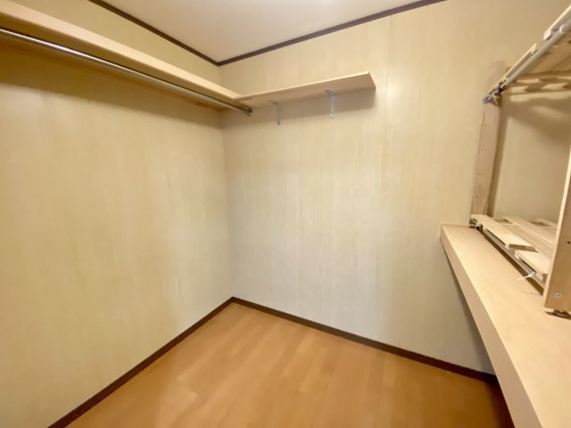 衣類だけでなく季節家電やスーツケースもすっきり収まる、大容量のウォークインクローゼットです。ハンガーパイプと棚が設置されており、収納計画が立てやすい造り。ご家族の衣類をまとめて管理できますね。