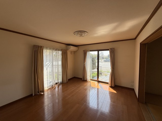 大きな窓から射し込むあたたかな陽光とナチュラルな木目の床やインテリアがやわらかな雰囲気のリビングルームです。