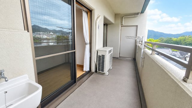 奥行きのあるゆったりとしたバルコニー。洗濯物を干すスペースをしっかり確保でき、スロップシンクも備わっています。バルコニーからは緑豊かな山並みを望むことができ、開放感のある眺望も魅力です。　