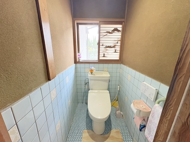 明るく清潔感のあるトイレ空間です。窓が設けられているため自然光を取り込みやすく、換気にも配慮された設計となっています。落ち着いた色合いのタイルが温かみを演出し、毎日気持ちよく利用できる快適な空間です。