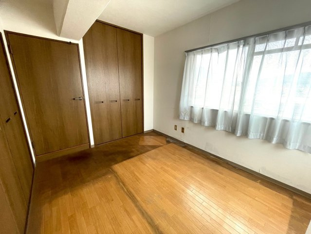 壁一面の大型クローゼットが魅力の洋室。収納力豊富で、お洋服や季節用品もすっきり片付きます。窓からの陽光が心地よく、寝室や書斎にもぴったりの空間です。