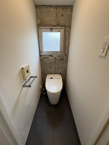 トイレには窓が設置されており、空気の入れ替えに便利です。窓側の壁一面をコンクリート打ちっぱなしにすることで、お家全体のデザインの統一感を大切にしています。