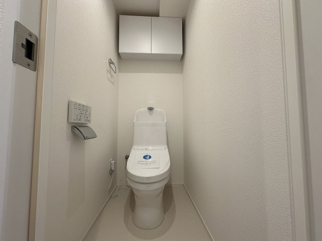 清潔感のあるおトイレです。上部に収納があるのは便利ですね。