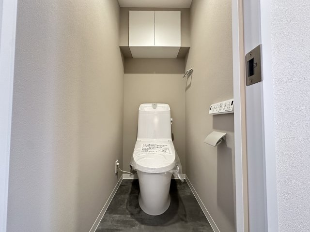 清潔感のあるスッキリとしたおトイレです。上部に収納も備わっていて、便利です。