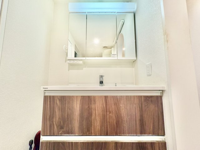 サッと拭くだけでお手入れ簡単な一体型洗面ボウルを採用。三面鏡裏の隠し収納や足元の大型キャビネットを完備しており、散らかりがちな小物をすっきり収めて洗面空間をいつでもクリーンに保てる仕様です。