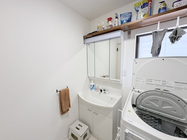 三面鏡付きの洗面化粧台を備えた清潔感のある洗面スペース。収納も充実しており、洗面用品や日用品をすっきり整理できます。洗濯機置場も同一空間にあり、家事動線がコンパクトにまとまっているのも魅力。