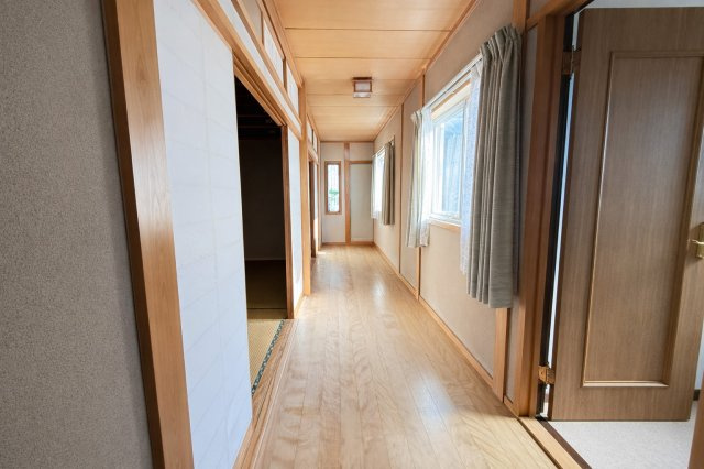 木の温もりが感じられる2階廊下は、落ち着いた雰囲気。窓からの採光で日中も明るく、風通しも良好です。各居室へとゆるやかにつながる設計で、プライベート空間への動線も確保。ゆとりある広さが魅力です。　