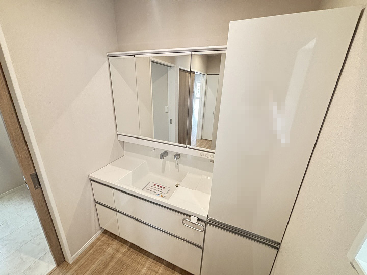 鏡裏に収納できる三面鏡。水栓は根元に水が溜まりにくく、お手入れがしやすい壁付タイプ。スクエア型の洗面ボウルは片側にステップがあり、濡れたコップなどを置くのに便利。隣接した収納は、タオル類等を収納可能◎