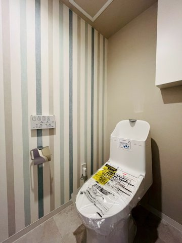 トイレは、ストライプのベージュを拾ったクロス合わせがかわいらしい空間です。　温水洗浄便座完備で快適な使い心地。