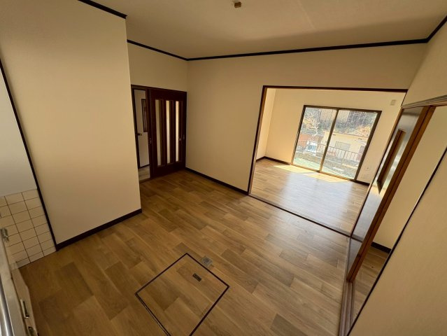 木目調のフローリングが温かみを感じさせるダイニング空間。隣接する洋室とつなげて使うことで、より広々とした空間として活用可能です。大きな開口部からは自然光が差し込み、明るく快適な空間となっています。　