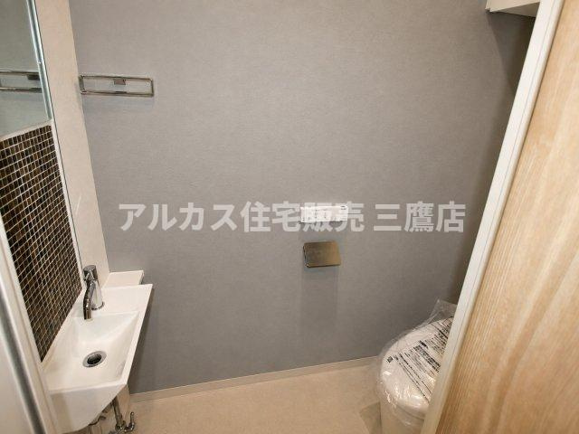 モザイクタイルと手洗いボウルがアクセントになった、スタイリッシュな手洗いカウンター付きトイレ。