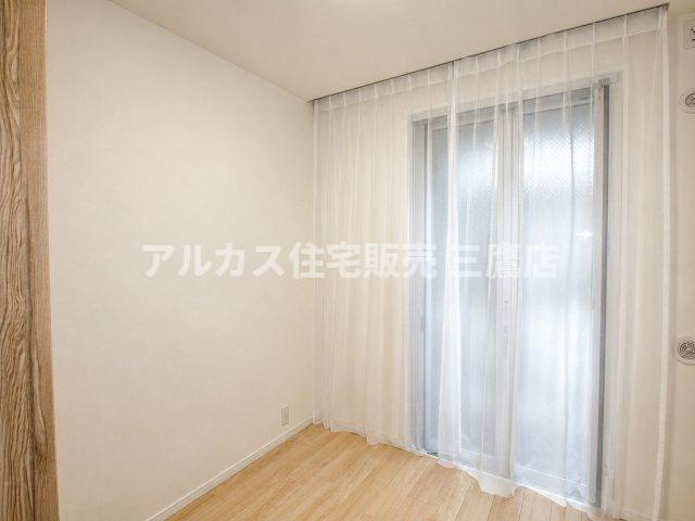 白を基調とした壁面とナチュラルなフローリングが心地よい、シンプルな洋室。
