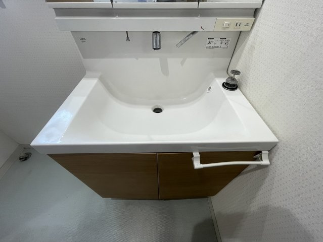 三面鏡タイプの洗面化粧台を採用しており、収納力と使いやすさを兼ね備えています。鏡裏収納もあり、洗面用品や小物類をすっきり整理可能。広めの洗面ボウルで朝の身支度やお掃除もしやすい仕様です。