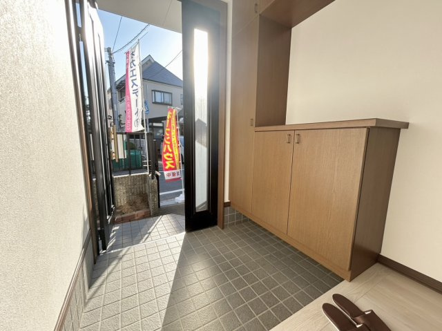 温かみのある木目調のシューズボックス完備。上下にしっかり収納でき、中央の棚には小物を飾れます。