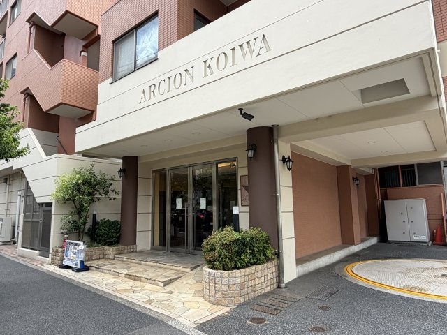 品格と安心感を漂わせる、重厚感あふれるエントランス　大きく刻まれた銘板と緑豊かな植栽が住まう方・訪れる方を優しく出迎えます。細部まで整えられたアプローチが、暮らしの質の高さを物語る佇まいです。