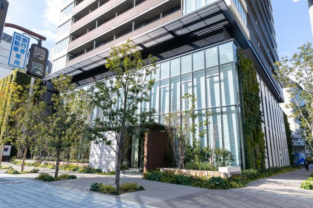 【エントランス外観】敷地内に配植した多彩な木々に溶け込み、周辺や街並みとの調和を目指した佇まい。