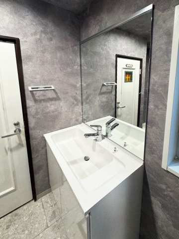 グレーの石目調クロスと大きなミラーが印象的なパウダールーム。毎朝の準備が、心整う特別な時間へと変わります。