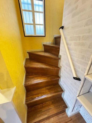 イエローのアクセントクロスが空間を明るく彩る階段。毎日の昇り降りが楽しくなる意匠です。