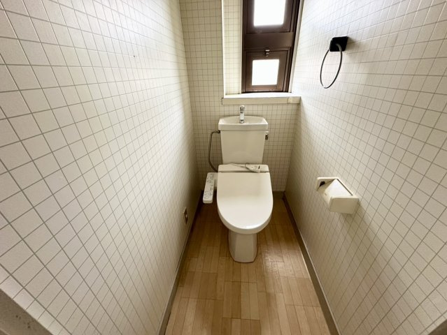 清潔感のある2階トイレは、温水洗浄便座を備えた快適な空間です。手洗い付きタンクを採用しているため衛生的に利用でき、窓から自然光が差し込むことで明るく爽やかな雰囲気を演出しています。