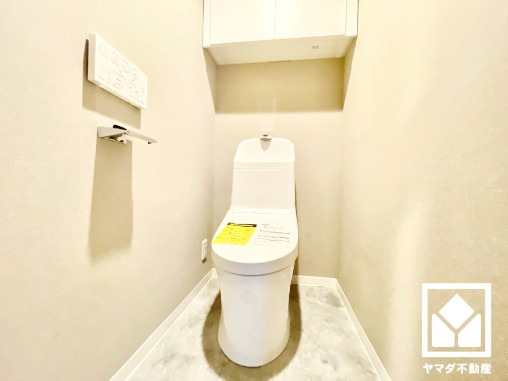 明るく清潔感溢れるトイレです。温水洗浄便座付きで、季節を問わずいつでも温かい便座をお使いいただけます。トイレットペーパーのストックや消耗品置き場などとしてお使いいただける吊戸棚を備えています。