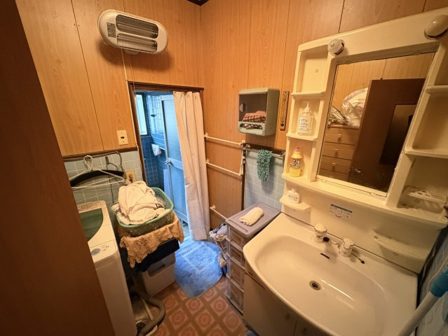 洗面台と洗濯機置場がまとまった脱衣室で、家事動線がスムーズ。収納棚が設けられており、タオルや洗剤などを整理しやすい。浴室への動線も良く、毎日の身支度や洗濯が効率的に行える実用性の高いスペース。