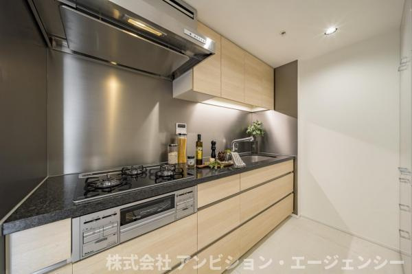 スタイリッシュな石目調天板のシステムキッチン。3口コンロと広々とした作業スペースで料理も捗ります。