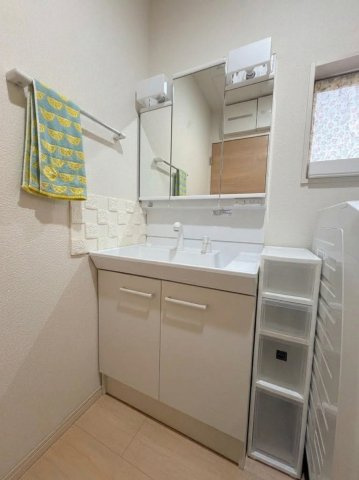 白でまとめた清潔感ある洗面空間。三面鏡と収納を備えた洗面台。朝の身支度をすっきり　支えます。