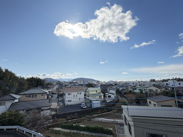 2階ベランダからの眺望。開放的な眺望が広がり、遠くの山並みまで見渡せます。日当たり良好で、1日を通して明るい光が差し込む立地です。