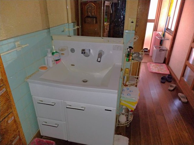 広々とした洗面台が設置されており、朝の身支度もゆったり行える空間です。鏡も大きく使い勝手が良く、収納スペースも確保されています。脱衣スペースから廊下へと続く動線もスムーズで、生活しやすい設計。