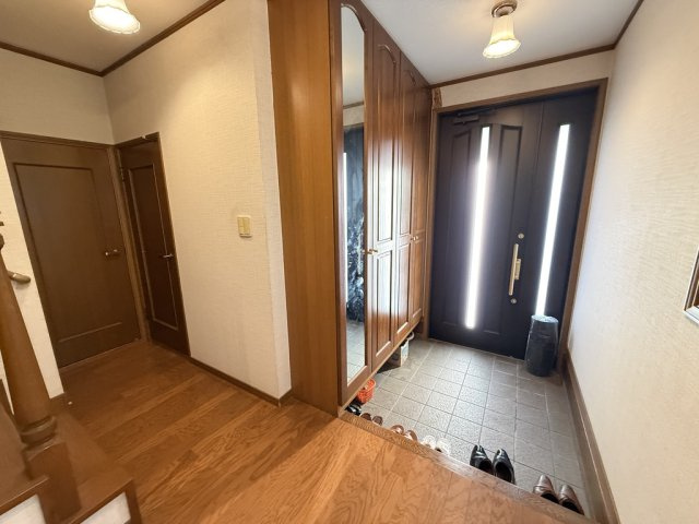 木の温もりが感じられる落ち着いた玄関ホール。縦に光を取り込む採光ドアが明るさを演出し、空間全体を柔らかく照らします。シューズボックス付きで帰宅時にほっと安らげる、上品で温かみのある玄関です。
