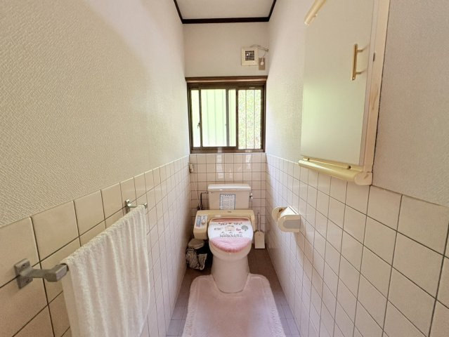 奥行きを確保したトイレスペースです。正面には窓が設けられているため、日中は自然光を取り込みやすく、使用後の換気がしやすい点も魅力。壁の下部にはタイルが使用されており、お手入れのしやすさにも配慮。